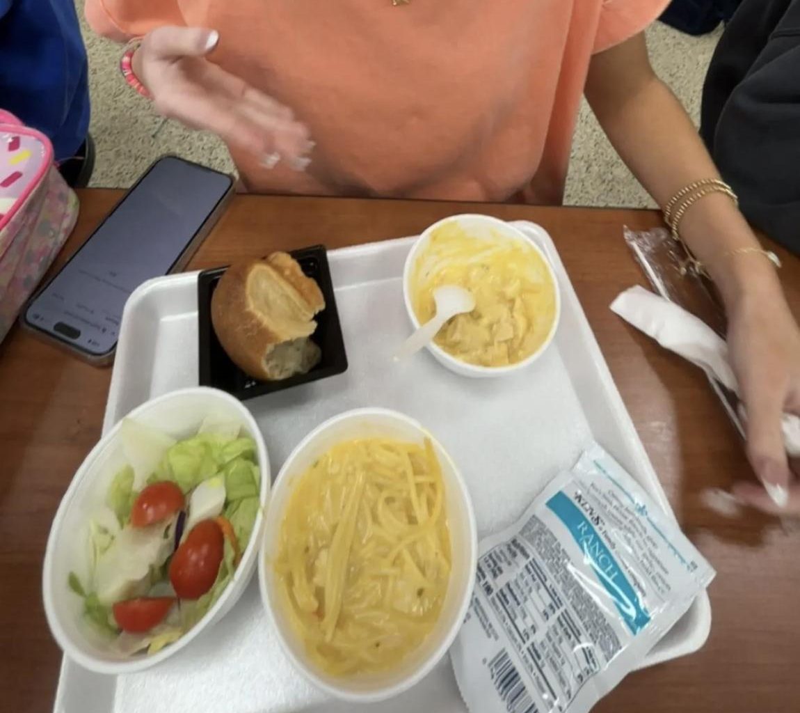 Senior Hallie Flynn explains to her lunch table how fabulous the chicken spaghetti is.