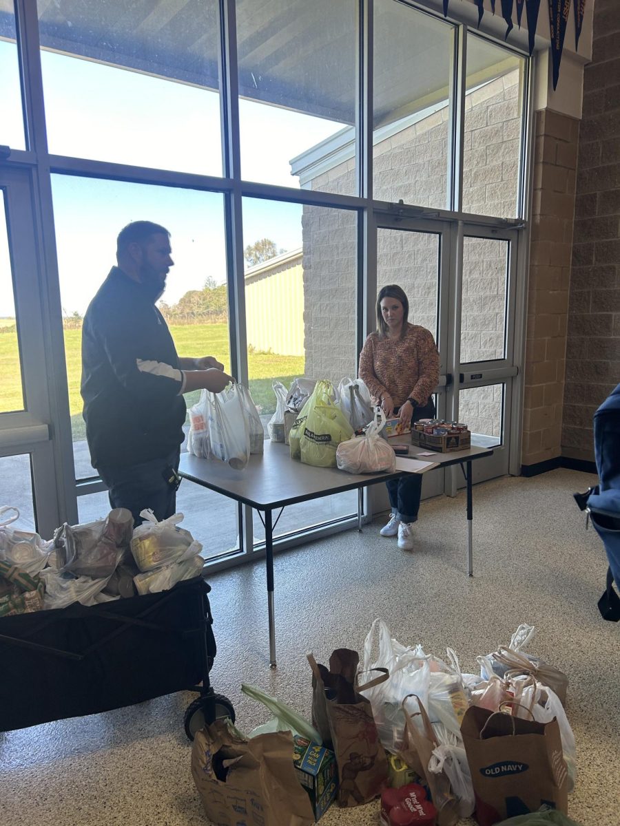 Principal Stephen Cox and Vice Principal Kenzie Graph sort cans from food drive.