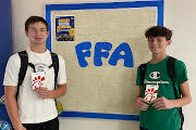Grayson Berg and Mason Catron receive gift cards for winning FFA scavenger hunt.
