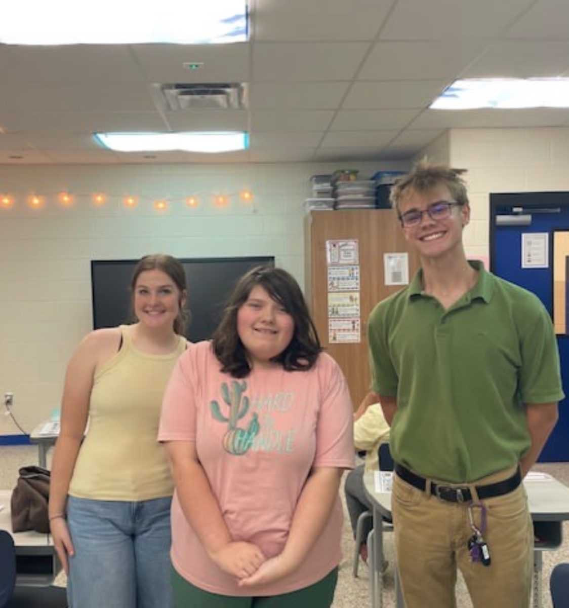 Seniors Calla Rudolph (left) and Ian Reed (right) direct freshman Hazel Whittington (center) in a lab about air pressure.